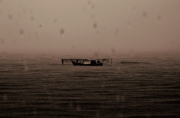 Barco abandonado lluvioso mar oscuro