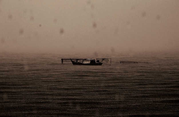 Barco abandonado lluvioso mar oscuro