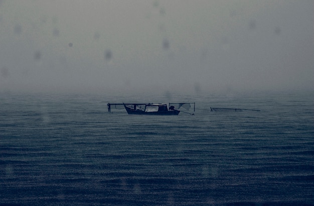 Barco abandonado lluvioso mar oscuro