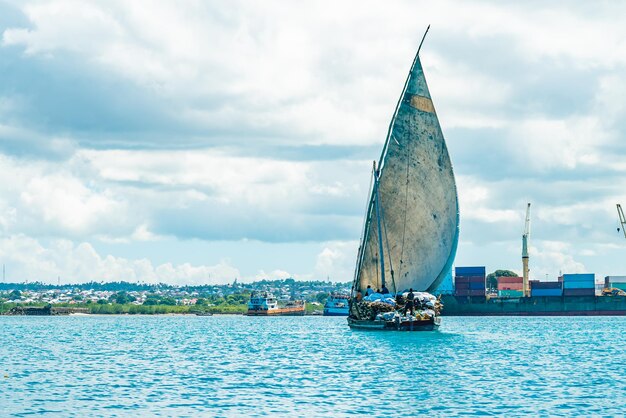 Barco de madera con madera en agua del océano Índico rumbo al puerto de Stone Town. Zanzíbar, Tanzania