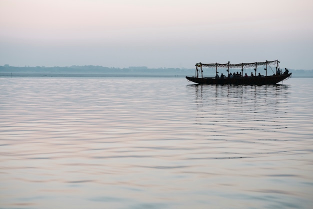 Barco de madera navegando en el río Ganges en Varanasi, India