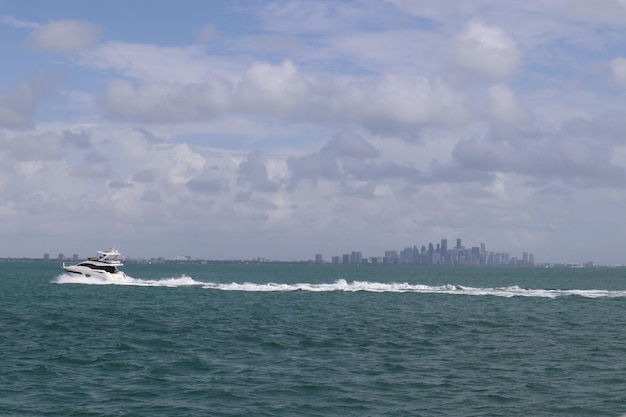 Barco en el mar azul con edificios de la ciudad en la superficie