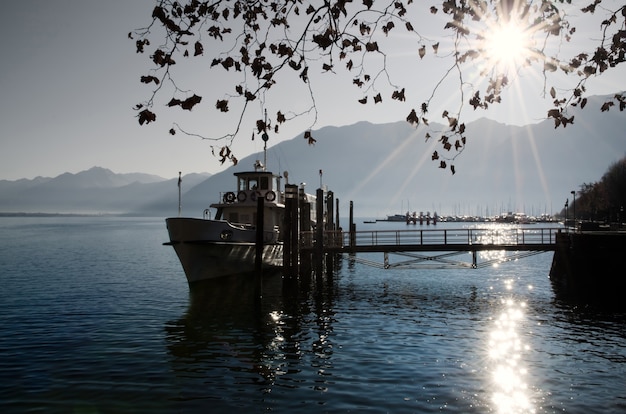 Barco de pesca en un lago alpino con hermosos rayos de sol en suiza