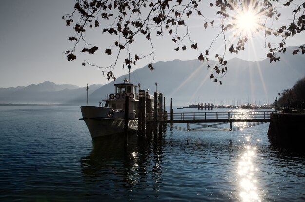 Barco de pesca en un lago alpino con hermosos rayos de sol en Suiza