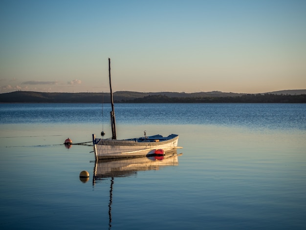 Barco de pesca en el río con la hermosa puesta de sol de fondo