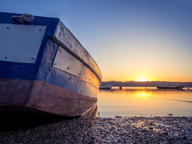 Barco de pesca en el río con la hermosa puesta de sol