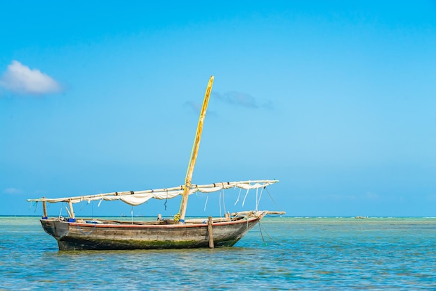 Barco pesquero en aguas del océano Índico con marea baja. Zanzíbar, Tanzania