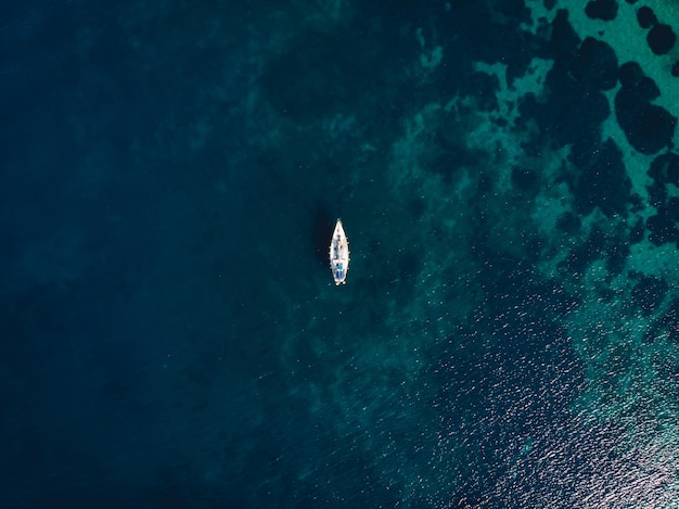 Barco único en medio del mar azul claro
