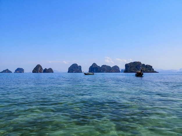 Barcos en agua de mar clara en un día soleado