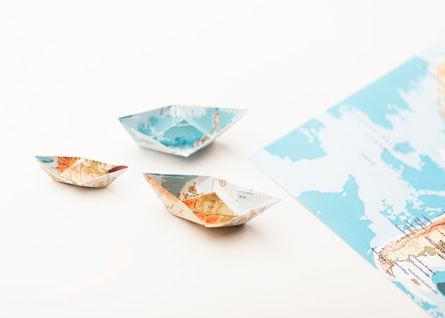 Foto gratuita barcos de mapa del mundo de papel pequeño de ángulo alto