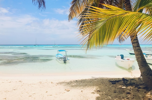 Barcos solitarios en agua turquesa antes de la playa dorada