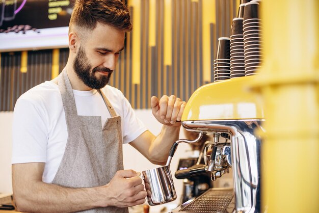 Barista calentando la leche en una cafetera