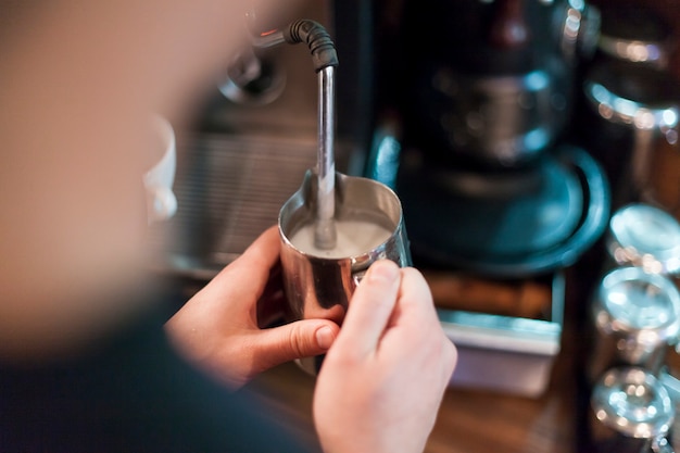 Barista de la cosecha que hace la espuma para el café