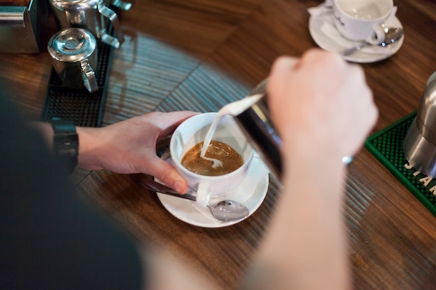 Barista de la cosecha que hace latte agradable