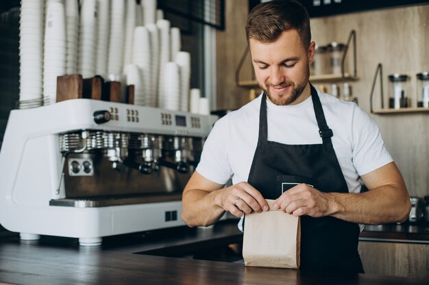 Barista empacar bocadillos para llevar en una cafetería.