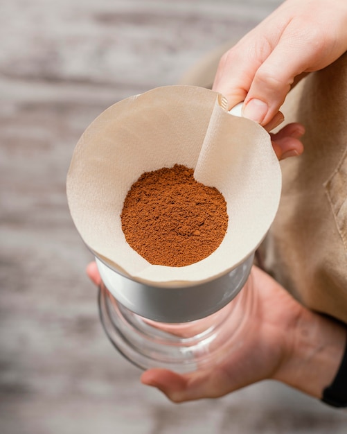 Barista femenina sosteniendo el filtro de café sobre la jarra