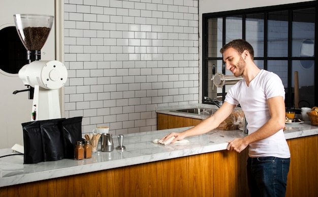 Barista limpiando el mostrador con el paño