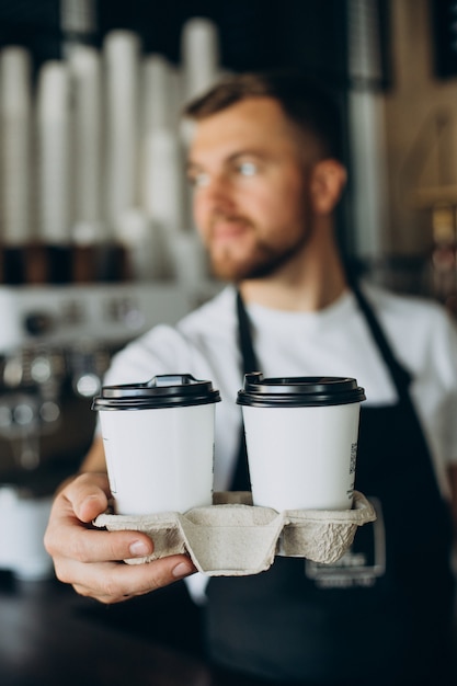 Foto gratuita barista masculino con café para llevar