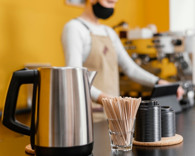 Barista masculino Defocused en el mostrador con hervidor de agua