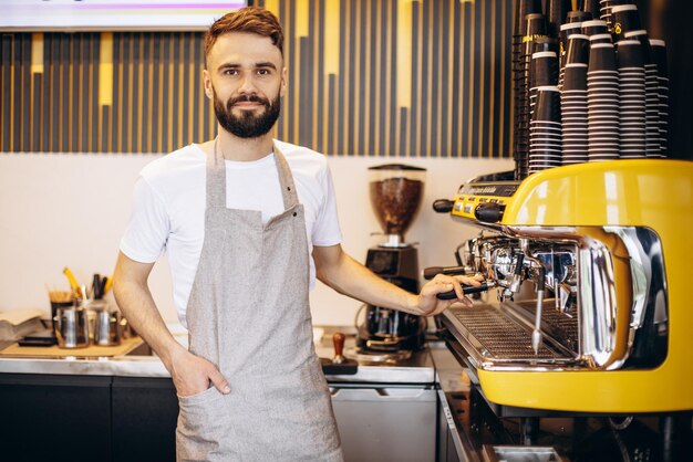 Barista masculino joven que trabaja en una cafetería