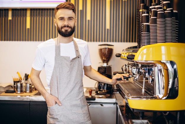 Barista masculino joven que trabaja en una cafetería