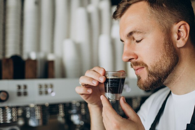 Barista masculino preparando café en una cafetería.