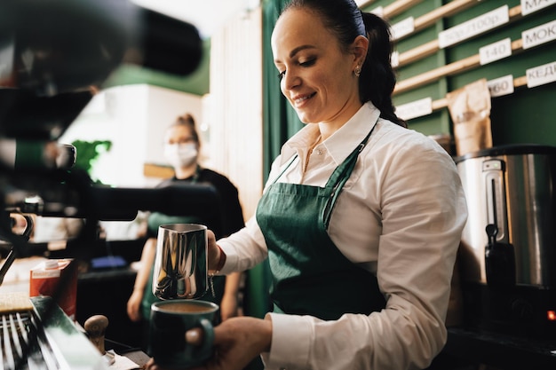 Barista mujer caucásica en el trabajo haciendo café