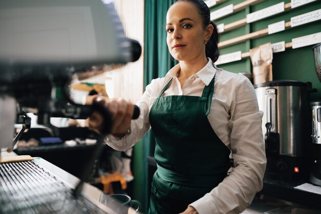 Barista mujer caucásica en el trabajo haciendo café