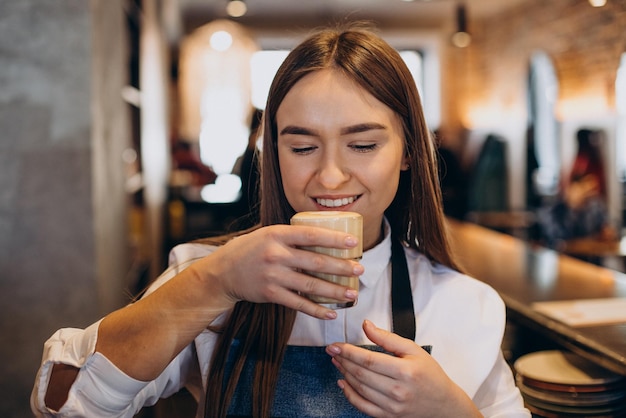 Barista preparando café con leche en una cafetería