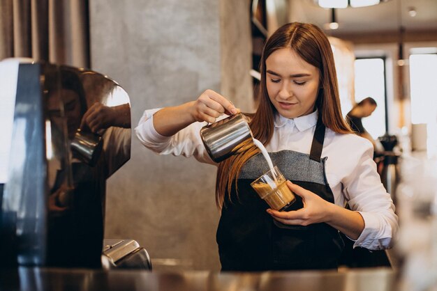 Barista preparando café con leche en una cafetería