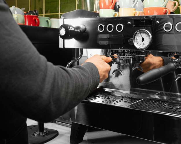 Barista de primer plano trabajando con máquina