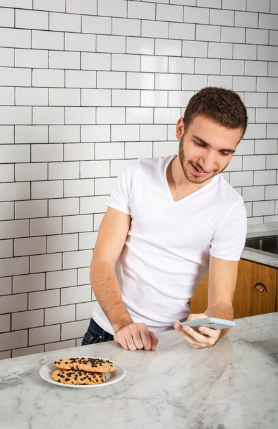 Barista tomando un descanso del trabajo y usando su teléfono inteligente