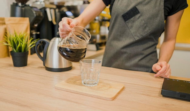 Barista vertiendo café en vaso