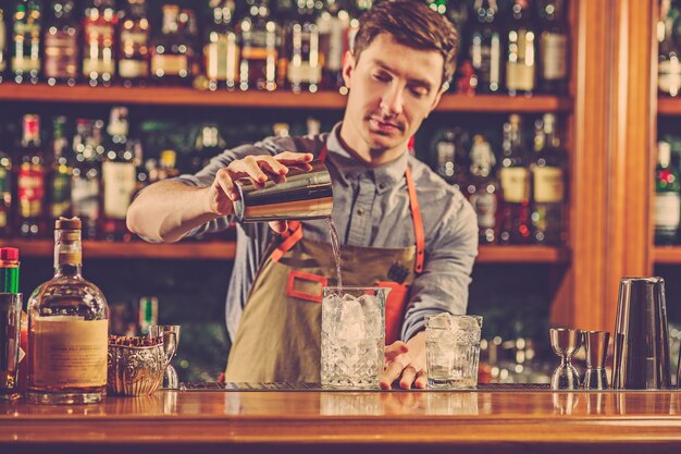 Barman experto prepara cócteles en la discoteca.