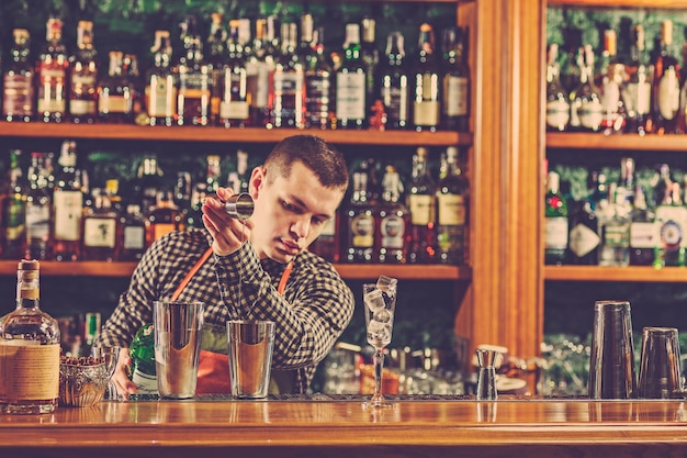 Foto gratuita barman haciendo un cóctel alcohólico en la barra del bar