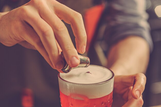 Barman haciendo un cóctel alcohólico en la barra del bar