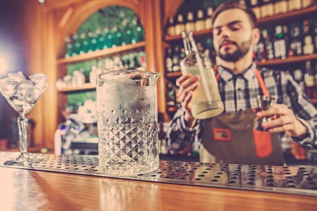 Foto gratuita barman haciendo un cóctel alcohólico en el mostrador del bar