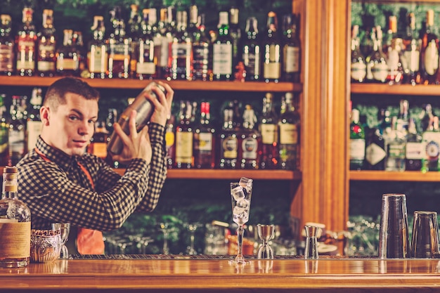 Barman haciendo un cóctel alcohólico en el mostrador del bar