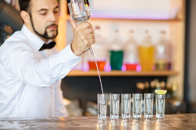 Barman en el trabajo, preparando cócteles.