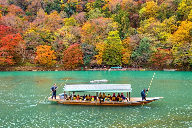 Barquero remar el barco en el río. Arashiyama en la temporada de otoño junto al río en Kyoto, Japón