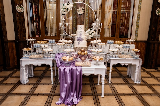 Barra de caramelo de boda pomposa y decorada con pastel de bodas de lavanda