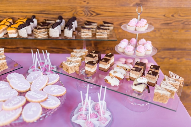 Foto gratuita barra de caramelo rosa servido con deliciosos dulces de chocolate y crema