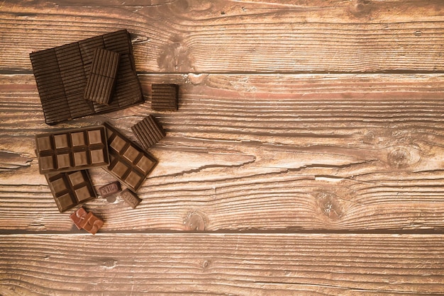 Barra de chocolate y piezas en la mesa de madera