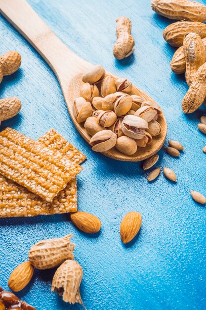 Barra de proteínas casera hecha con frutas secas en el fondo de textura azul