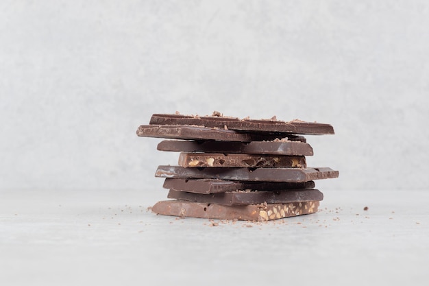 Barras de chocolate con nueces sobre superficie de mármol