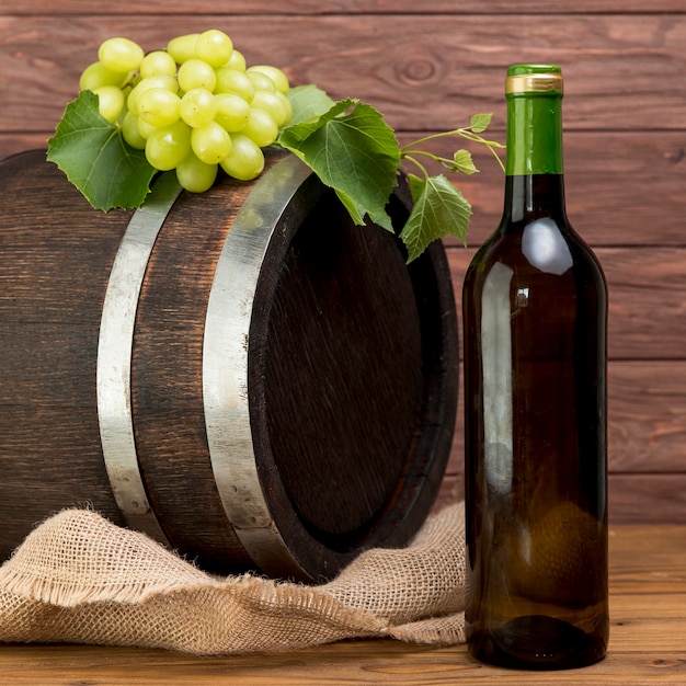 Foto gratuita barril de madera con botella y vaso de vino