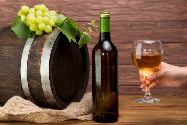 Barril de madera con botella y vaso de vino