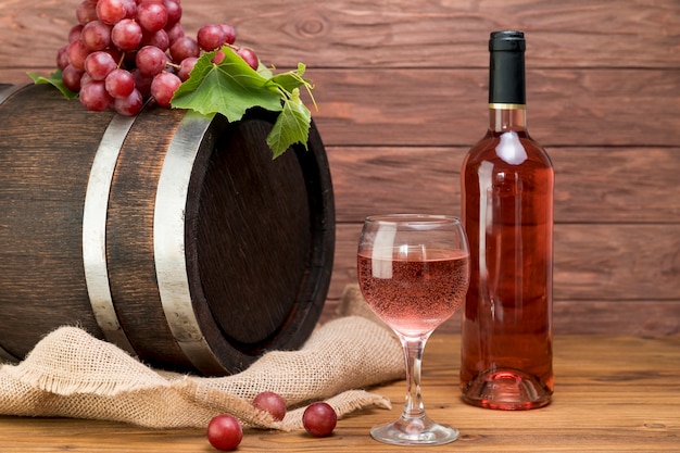 Barril de madera con botella y vaso de vino