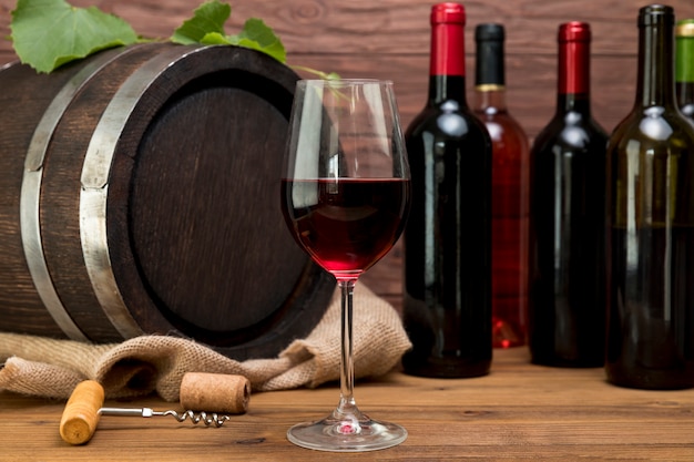 Barril de madera con botellas y vasos de vino