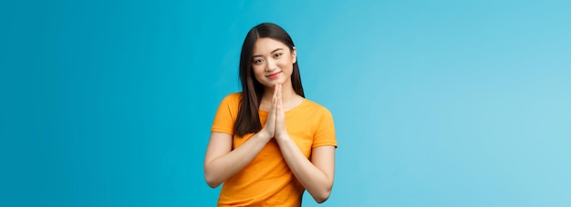 Foto gratuita bastante por favor chica pidiendo cortésmente linda encantadora mujer asiática sonriendo tiernamente tome las manos rezar grinni